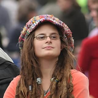 with glasses and a hat sitting in the crowd